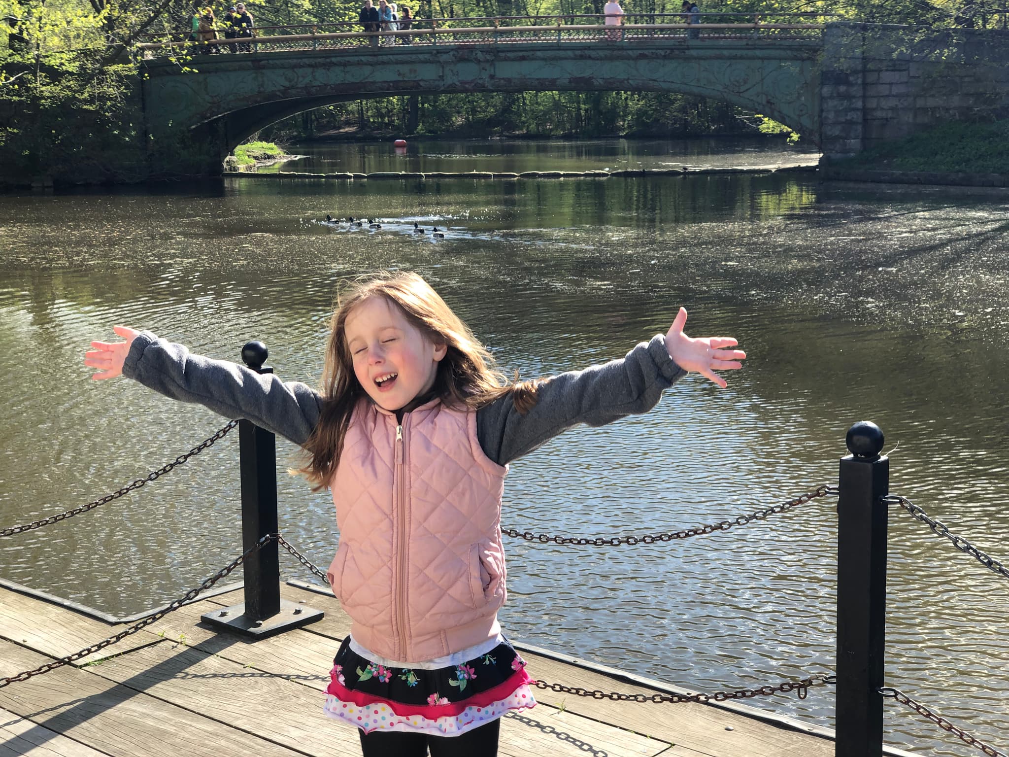 Maddie with arms wide open at the Prospect Park boathouse