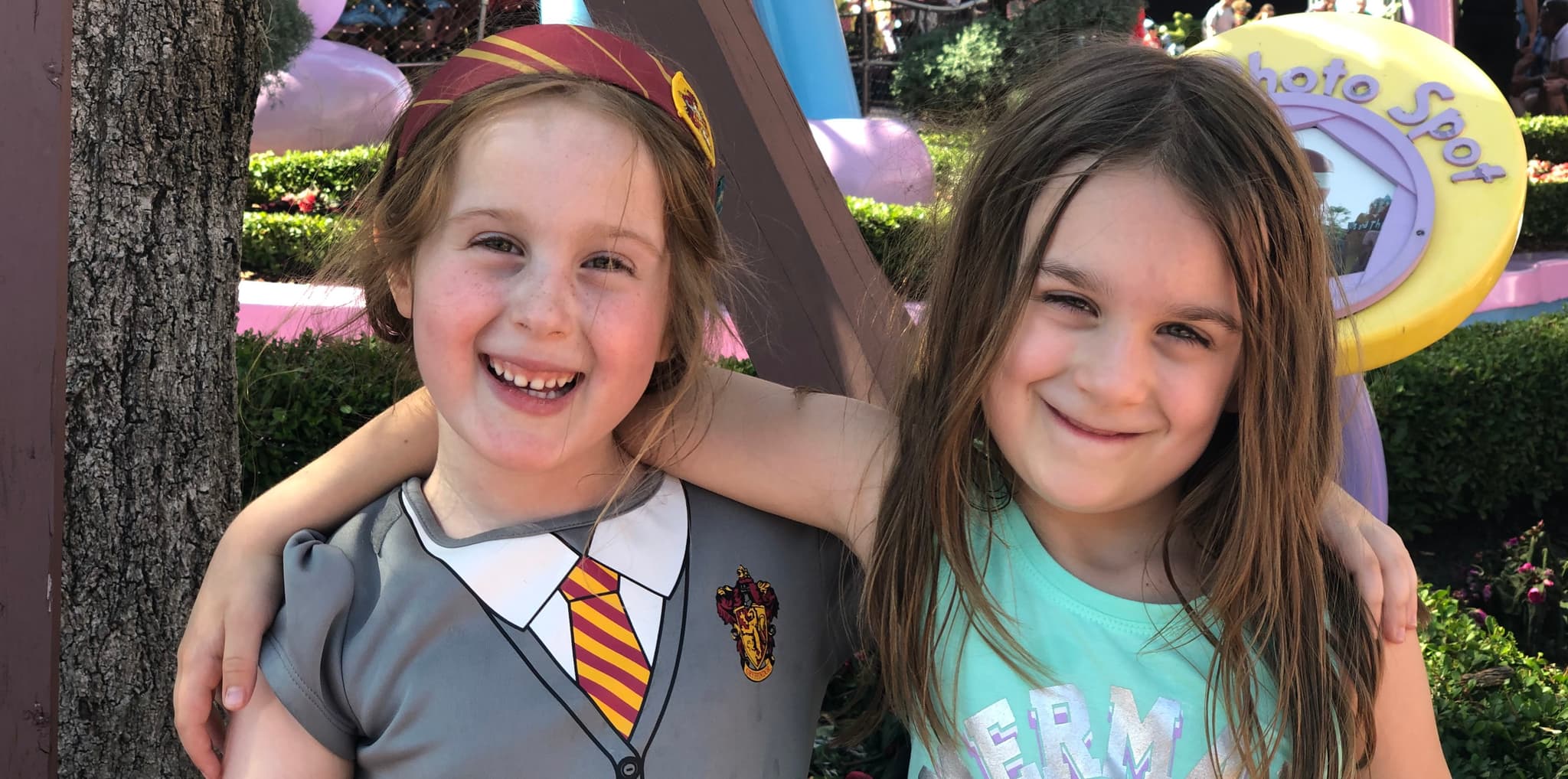 Maddie waving under cherry blossoms in Prospect Park